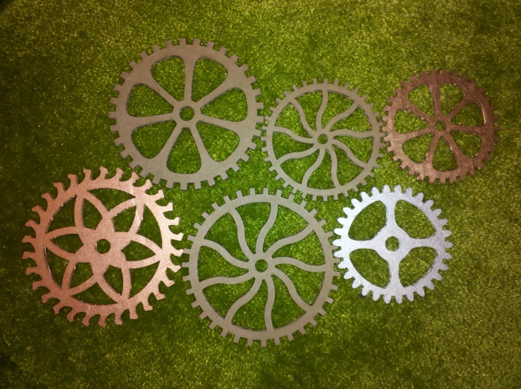 Six cardboard gears, some painted, some plain